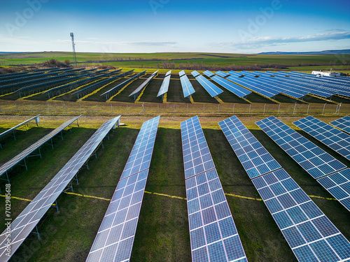 Solar panel produces green, environmentaly friendly energy from the setting sun. Aerial view from drone. Landscape picture of a solar plant that is located inside a valley
 photo