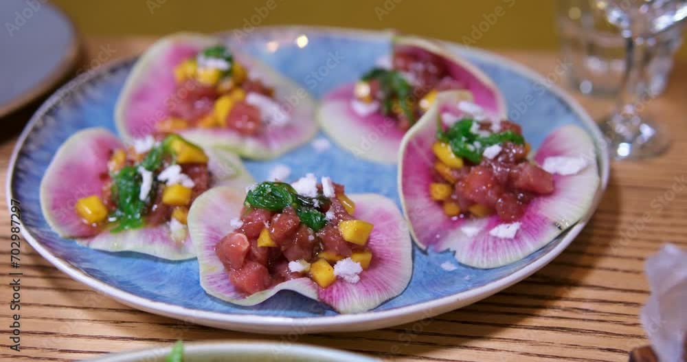 serving salad on Red radish petals of the vegetable cut look like dragon fruit hearts with red fish corn and greens on a blue plate wooden table restaurant delicious asian food serving salad on Red radish petals of the vegetable cut look like dragon fruit hearts with red fish corn and greens on a blue plate wooden table restaurant delicious asian food