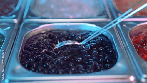 Close up shot of tasty, delicious, sweet boba tea bubbles stired by a metal spoon 