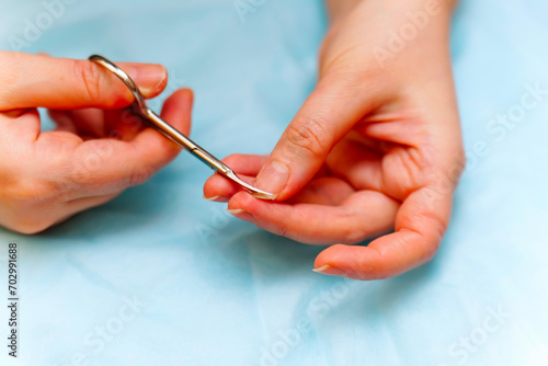 A girl cuts her fingernails with special scissors