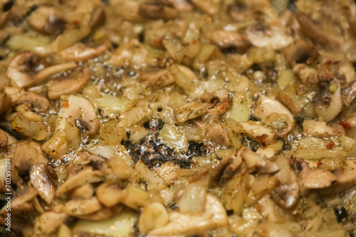 We cook mushrooms. Chopped mushrooms and golden onions in a frying pan close-up. Gastronomic background. Onions with mushrooms are fried in a frying pan. close-up, selective focus.