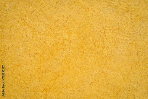 closeup background of yellow Huun Mayan handmade paper created in Mexico photo