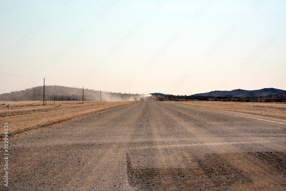 A deserted stony road in the hot desert foothills under a bright blue sky A deserted stony road in the hot desert foothills under a bright blue sky