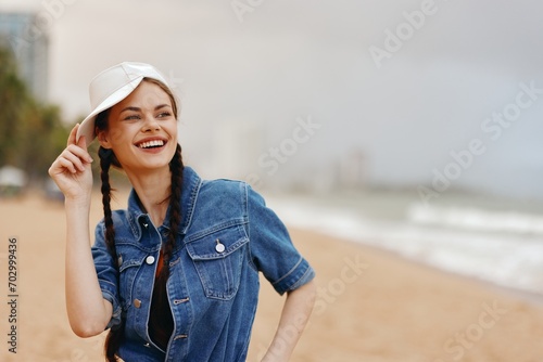 Joyful Caucasian Woman Enjoying Summer Vacation by the Sea in a Stylish Hat and Trendy Fashion: Pretty, Attractive, and Happy in the Relaxing Beach Background. © SHOTPRIME STUDIO