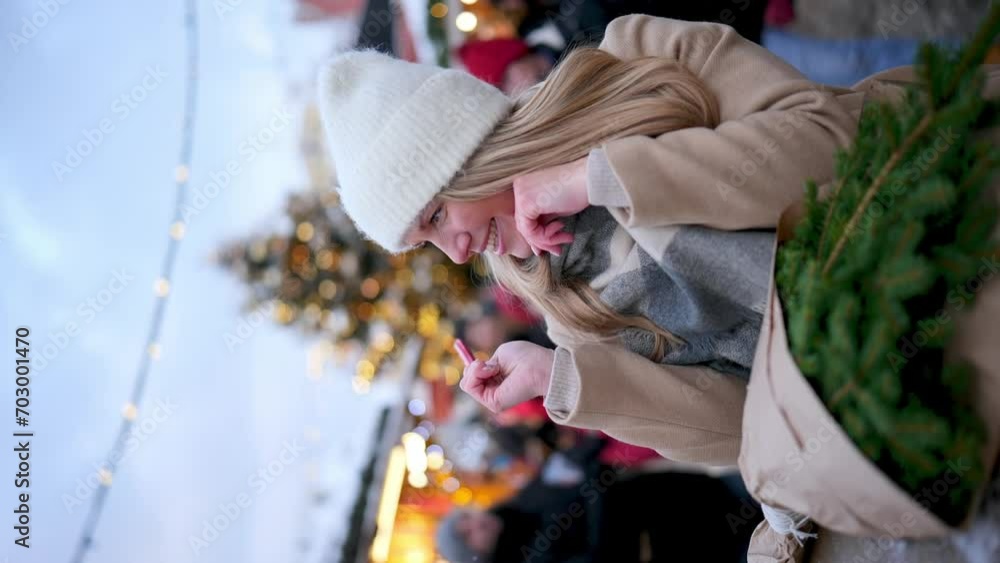 Portrait of young smiling woman holding heart shape lollipop on Christmas market Portrait of young smiling woman holding heart shape lollipop on Christmas market