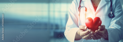 close up of female doctor hands holding red heart with stethoscope on background. healthcare and medical service concept photo