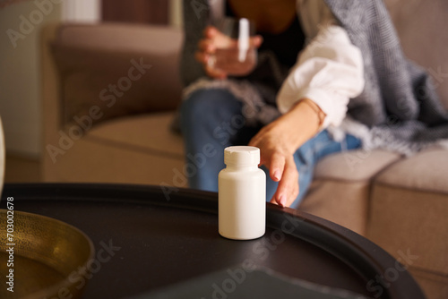 Woman sits with a glass of water on the sofa