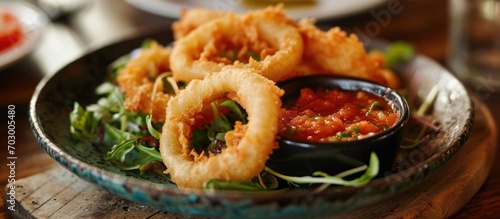 Crispy onion rings with rocket salad and salsa dip.