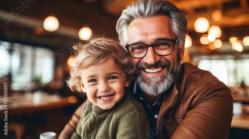 Father son bond  hipster son embracing senior father at home for father s day celebration photo