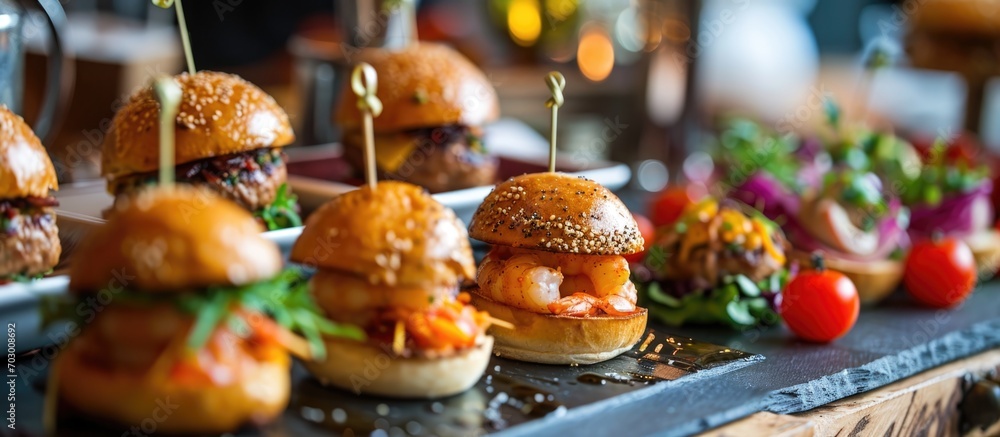Catering provided for event guests: mini meat burgers, shrimp, canapes, rolls, a lavish table.