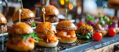 Catering provided for event guests: mini meat burgers, shrimp, canapes, rolls, a lavish table.