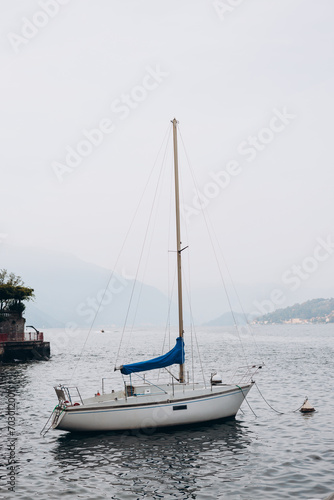 White sailing boat on lake Como. Water sports. The concept of a luxurious lifestyle, mountain background