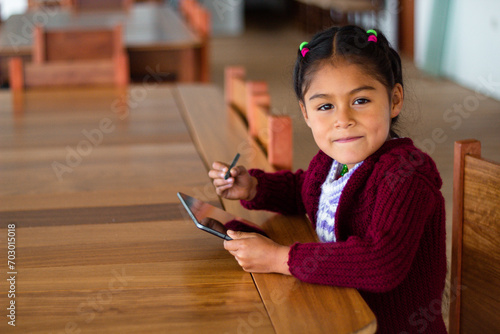 Una niña campesina en el aula conectada en Tablet, educación rural, Niña bonita aprendiendo y dibujando con el profesor en línea en tablet digital clases,