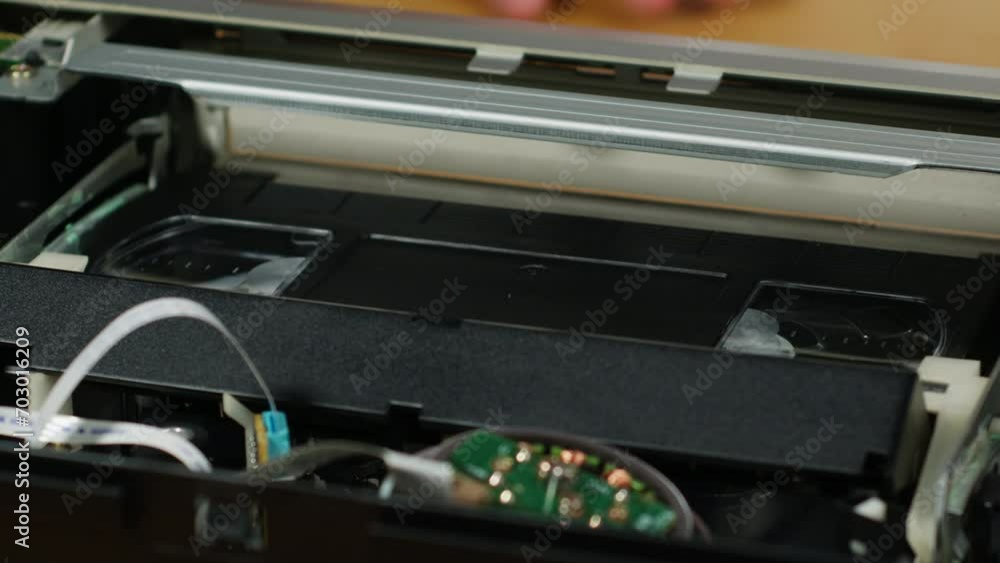 VHS PLAYER, Old video recorder inside close-up, VHS. Retro player in neon blue light, vintage video cassette broadcasting, audio tape. VHS PLAYER, Old video recorder inside close-up, VHS. Retro player in neon blue light, vintage video cassette broadcasting, audio tape.
