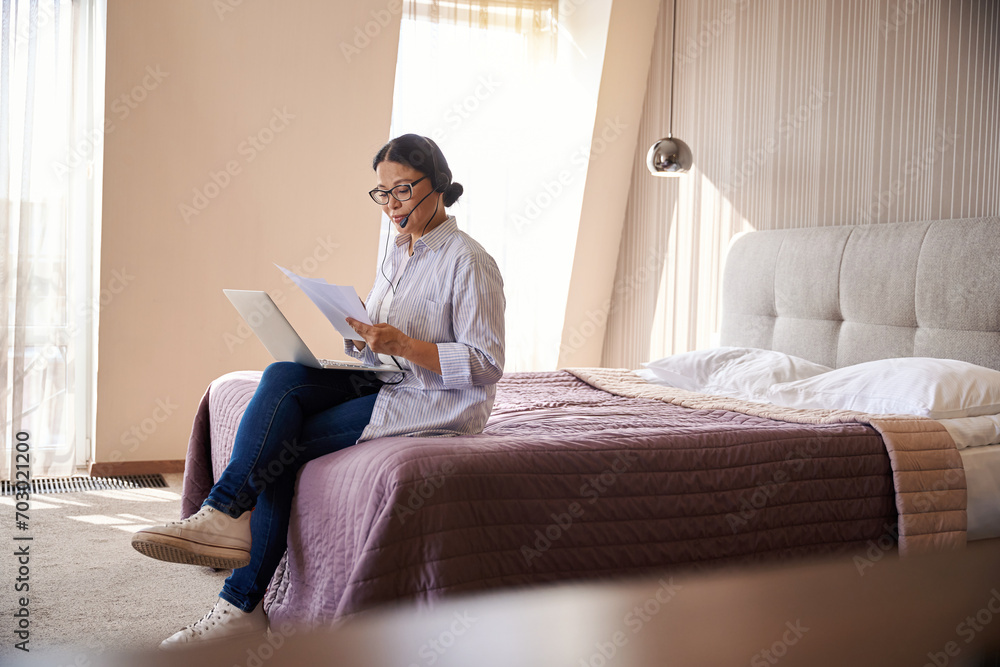 Female entrepreneur is working in hotel room during business trip Female entrepreneur is working in hotel room during business trip