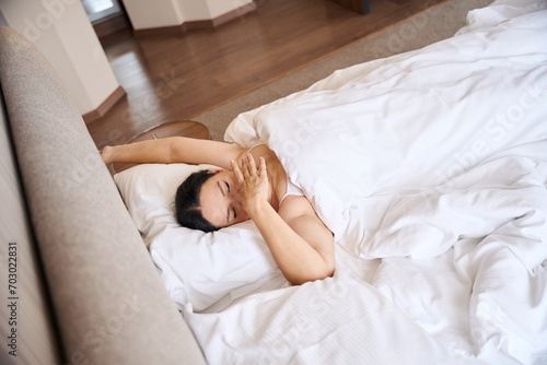 Adult woman waking up from sleep in her hotel room