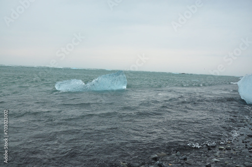 Crystal clear ice chunks floating on the waves of Diamond beach in Fellsfjara Jokulsarlon on Iceland