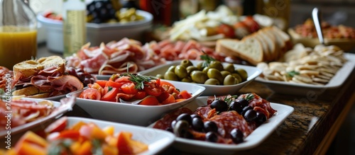Gourmet buffet featuring Italian cold meats  antipasti  tapas  wine  salmon sandwiches  and olives.