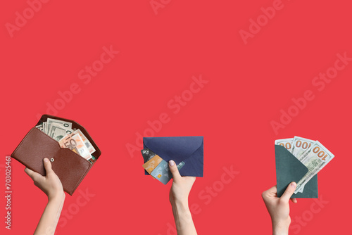 Female hands with wallets, envelopes and money on red background