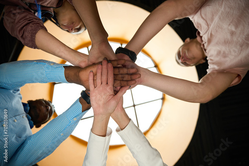 Hardworking colleagues folding hands together as symbol of friendly team