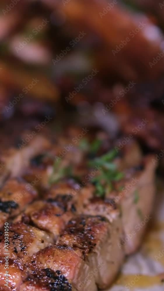 Cook shifts the ready-made pork ribs from the cutting board to a plate with sauces and sausages. Cook shifts the ready-made pork ribs from the cutting board to a plate with sauces and sausages.