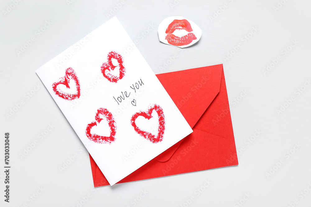 Greeting card for Valentine's Day celebration, red envelope and lipstick kiss mark on grey background