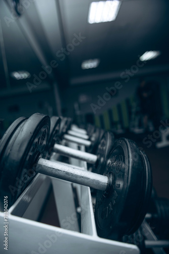 Dumbbell rack. Sports and gym. Equipment for strength training. Black set of dumbbells, many dumbbells on a rack in a sports fitness center