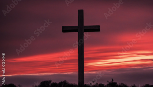The radiant crimson sky with piercing sunbeams slicing through billowing clouds, casting a shadow of the sacred cross embodying the story of Jesus Christ's sacrifice, crucifixion, and rebirth.