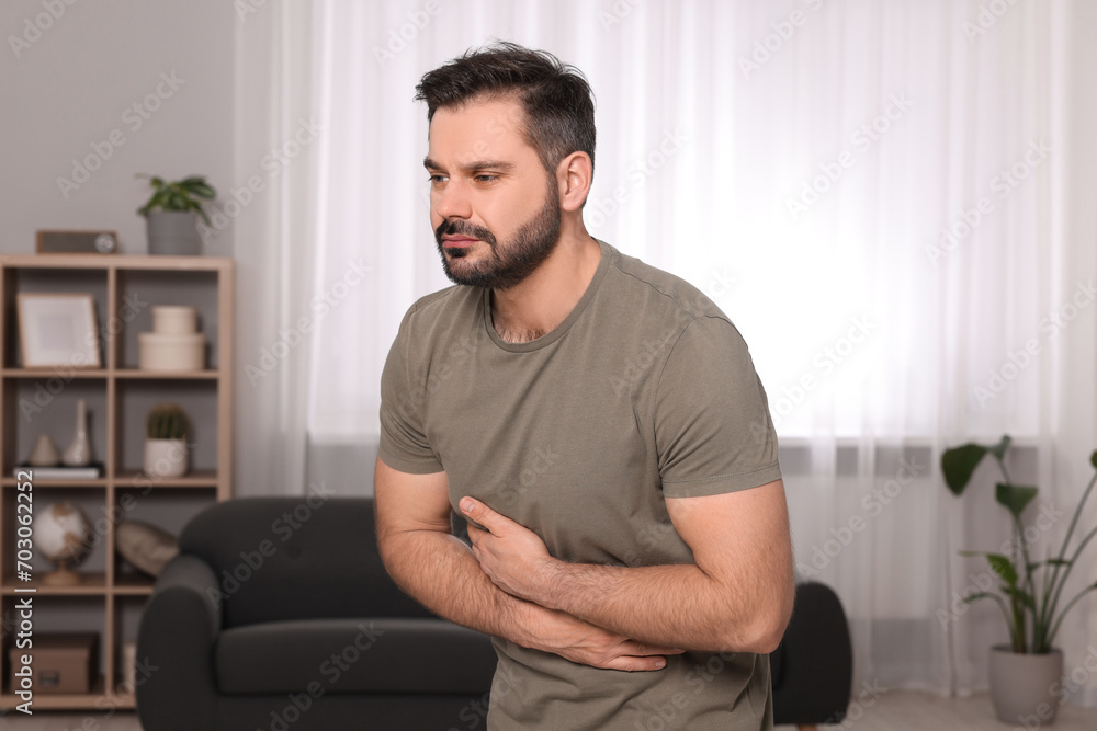 Man suffering from stomach pain at home Man suffering from stomach pain at home