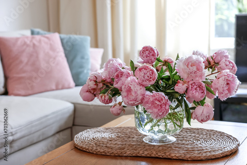 Beautiful pink peonies in vase on table at home, space for text. Interior design