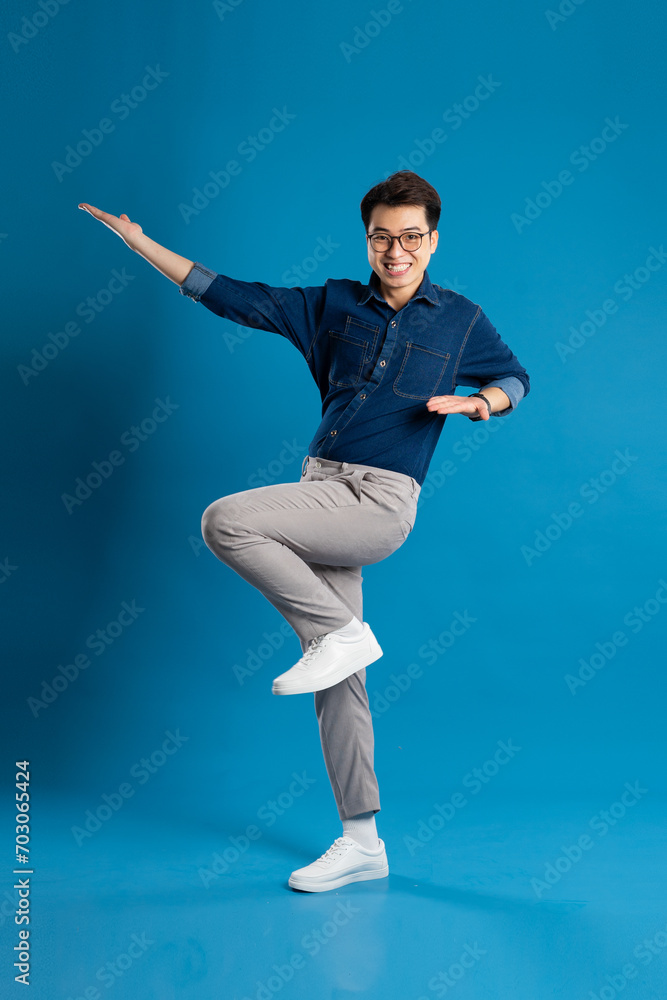 Portrait of young Asian business man posing on blue background Portrait of young Asian business man posing on blue background