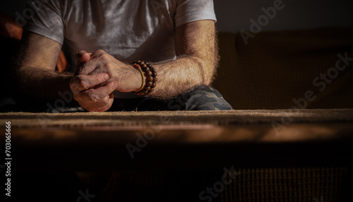 Portrait of mature man sitting on sofa with bracelets on wrist