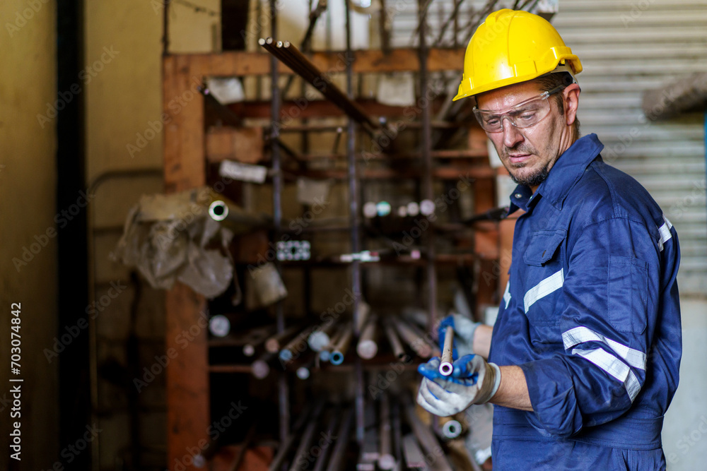 Caucasian white ethnicity worker working in metal lathing factory, male worker inspecting a metal works in factory storage room. Caucasian white ethnicity worker working in metal lathing factory, male worker inspecting a metal works in factory storage room.