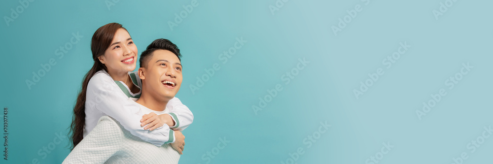 Young beautiful couple isolated on light blue background Young beautiful couple isolated on light blue background