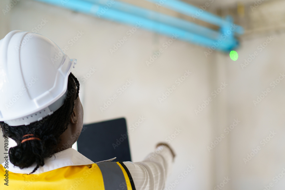 Senior professional African - American engineer inspects the pumping and water pipes system inside the build. Foreman inspects water pipe in building. Senior professional African - American engineer inspects the pumping and water pipes system inside the build. Foreman inspects water pipe in building.