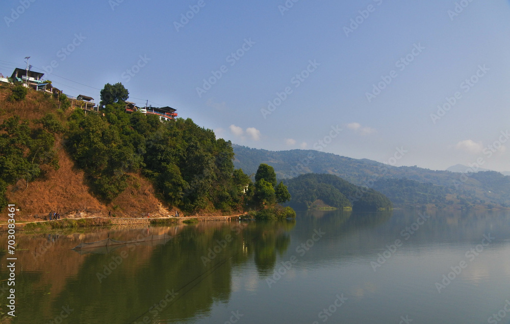 Views of the blue sky, rice fields, clear lake water and morning sunlight around Begnas Lake in Pokhara, Nepal.