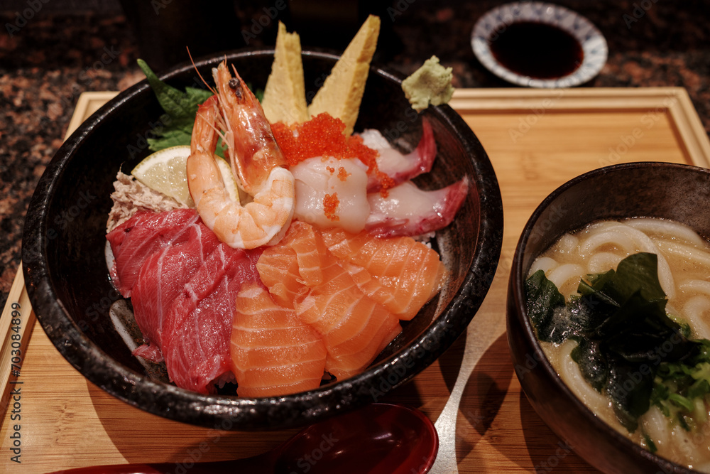 Top view of Sashimi Don, Danburi or Japanese rice bowl with various raw fresh slice of fish, shrimp, squid , scallop and tamago egg, on the wooden counter. Top view of Sashimi Don, Danburi or Japanese rice bowl with various raw fresh slice of fish, shrimp, squid , scallop and tamago egg, on the wooden counter.
