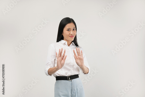 A young Asian woman raises her palms slightly outward, appearing to politely decline or gesture 