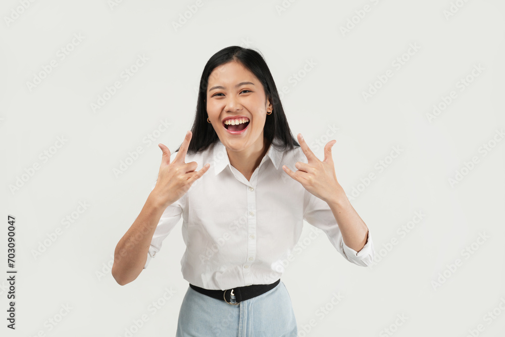 An Asian woman in a white blouse raises both hands in the An Asian woman in a white blouse raises both hands in the