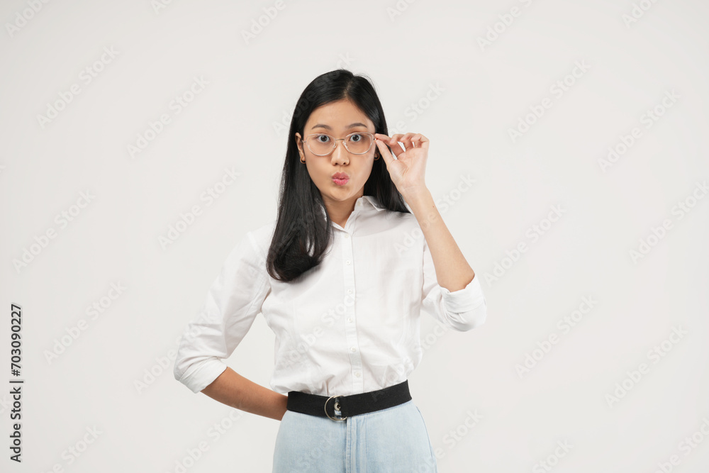 The Asian woman covers her mouth with her hand, looking surprised. She is wearing a white shirt, set in a studio environment. The Asian woman covers her mouth with her hand, looking surprised. She is wearing a white shirt, set in a studio environment.