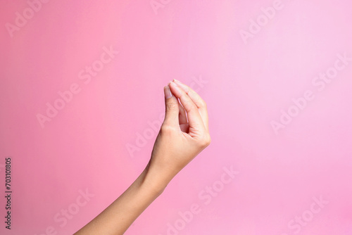 Hand doing Italian gesture with fingers together isolated over pink background