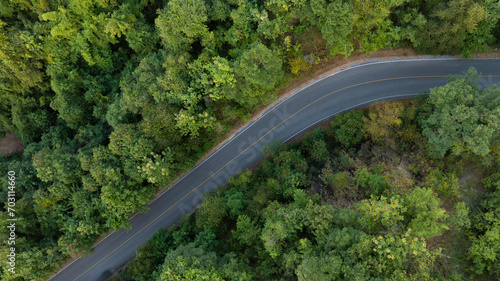 Aerial view of road dark green forest Natural landscape and elevated traffic roads Adventure travel and transportation ideas for the environment 