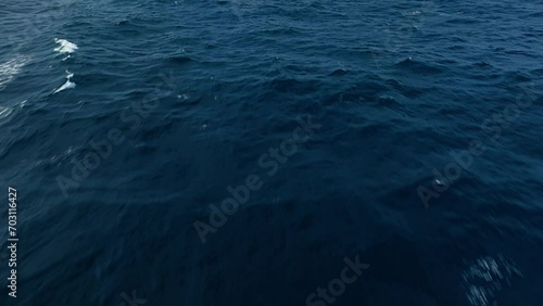 Bird's eye view of open ocean water soaring above shimmering depth of dark blue seas photo