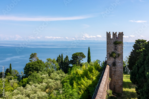 City walls Piransko obzidje with scenic aerial view of coastal town Piran, Primorska, Slovenia, Europe. Shimmering azure waters of Adriatic Sea. Tranquil Mediterranean summer atmosphere. Sightseeing photo