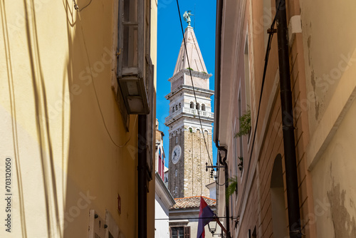 Stroll along narrow urban street that meanders its way towards magnificent St. George Parish Church. Old town of charming coastal town of Piran, Slovenian Istria, Slovenia, Europe. Sightseeing