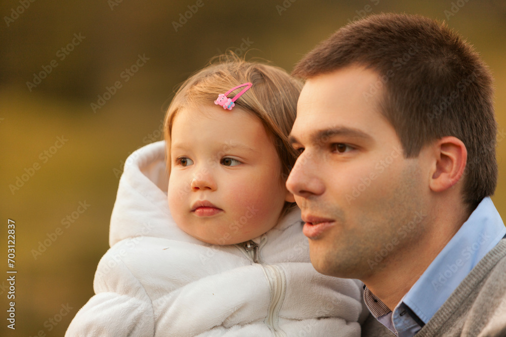 Father embraces daughter in soft evening light Father embraces daughter in soft evening light