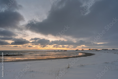 Dramatic sky over horizon and village by the ocean on a winter afternoon. Skallelv, Northern Norway photo