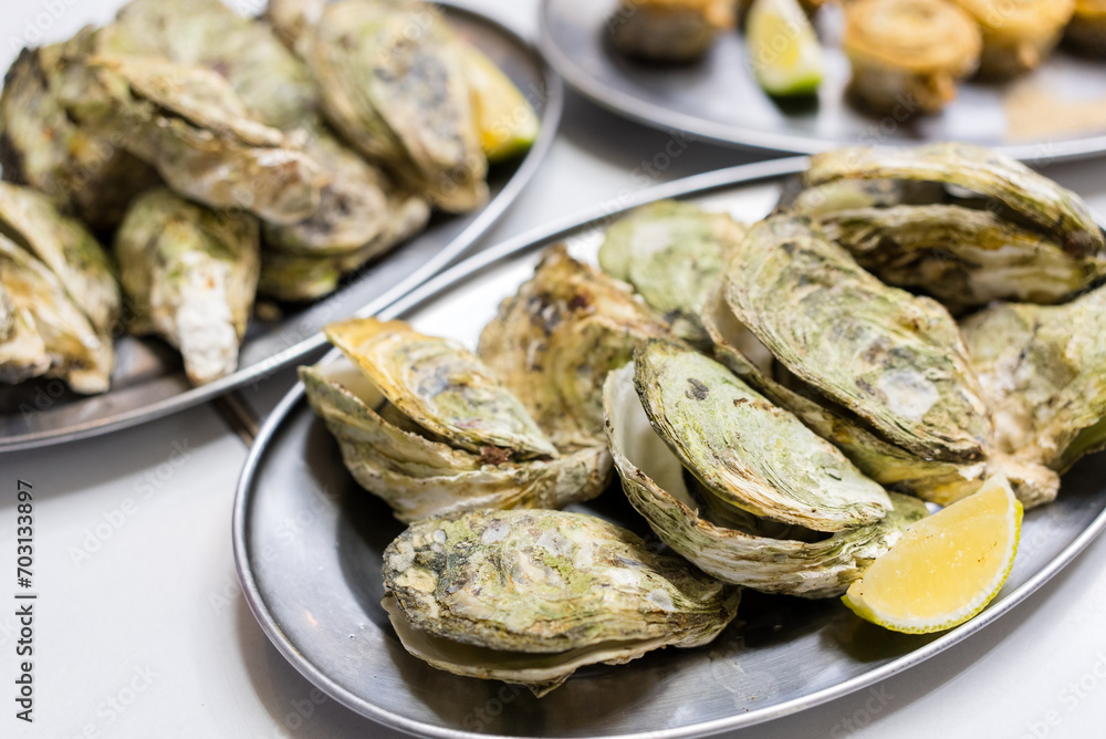Grill oysters with lemon on the plate Grill oysters with lemon on the plate