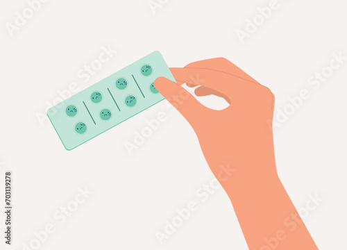 A Person’s Hand Holding Blister Pack Pills With Sad Face Emoji. Close-Up.