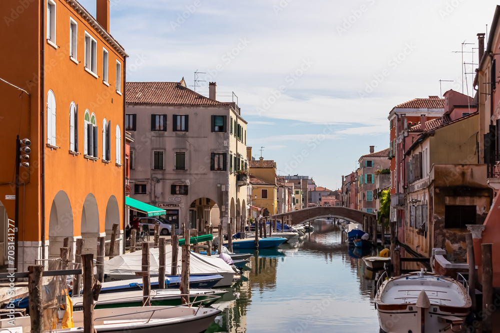 Scenic view of peaceful canal Vena nestled in charming town of Chioggia, Venetian Lagoon, Veneto, Italy. Small boats floating in calm water. Enchanting reflections create atmosphere of tranquility